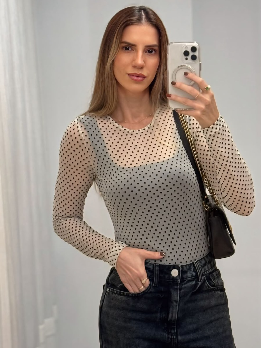 Fafá de blusa de tule poá e jeans escuro, com bolsa a tiracolo